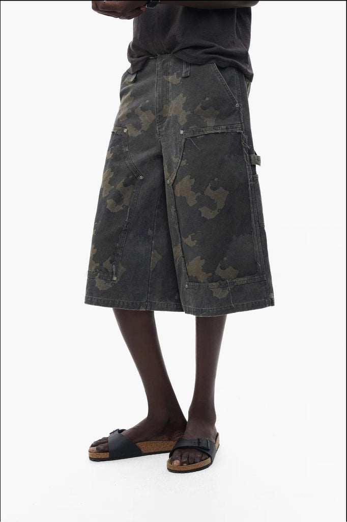 Person wearing a dark camouflage shorts on a white background